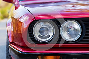 Headlights of a red, old, retro car, closeup