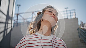 Headphone girl relaxing sunlight moving in tact song outdoors close up. photo