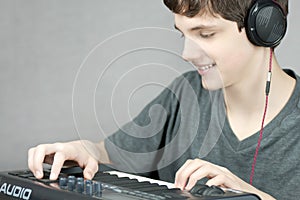 Headphone Wearing Teen Adjusts Keyboard