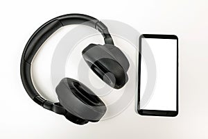 Headphones with Bluetooth technology on white background, with black phone paired for music lovers