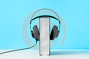 Headphones on book. Audiobook horizontal banner with copyspace. Online education and e-learning concept