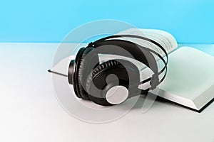 Headphones on book. Audiobook horizontal banner with copyspace. Online education and e-learning concept