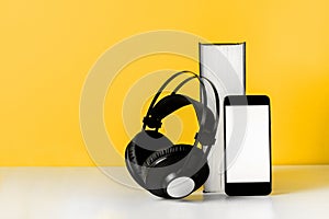 Headphones on book empty phone screen. Audiobook horizontal banner copyspace. Online education and e-learning concept