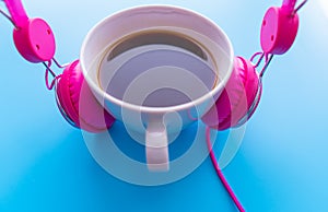 Headphones and coffee cup on blue background. Music concept. Top view with copy space