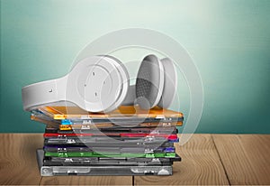 Headphones and compact discs on wooden background