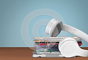 Headphones and compact discs on wooden background