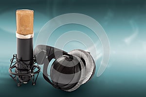 Headphones and condenser microphone on the green background