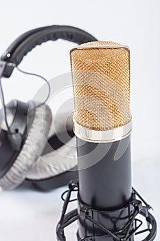Headphones and condenser microphone on the white background
