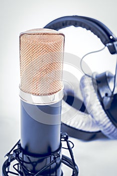 Headphones and condenser microphone on the white background