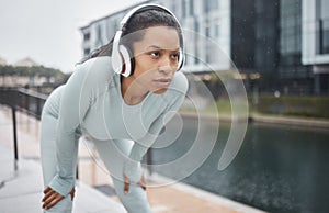 Headphones, fitness and runner woman on a urban street with motivation, music and exercise. City run, sport and marathon