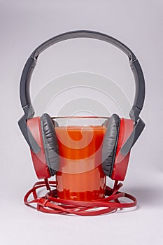 Headphones and a glass of tomato juice