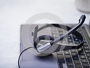 Headphones, headset, computer keyboard. Gray tones White background. Bright lighting. Close-up. Side view. There is an empty space