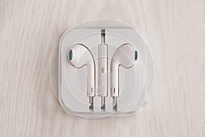 Headphones for Iphone in a box stacked on a white wooden desk