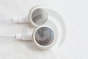 Headphones for Iphone white on white wooden desk close-up