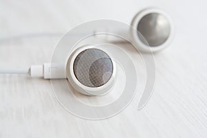 Headphones for Iphone white on white wooden desk close-up