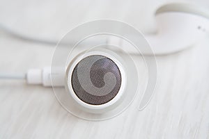 Headphones for Iphone white on white wooden desk close-up