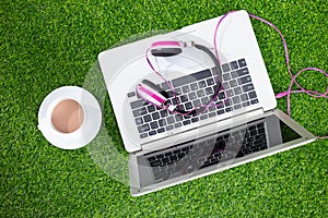 Headphones on the laptop on grass