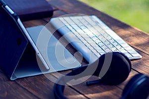 Headphones and laptop are on the table outdoor. Technology and lifestyle concept