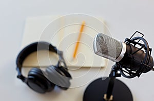 Headphones, microphone and notebook with pencil