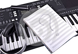 Headphones, microphone and notebook on piano
