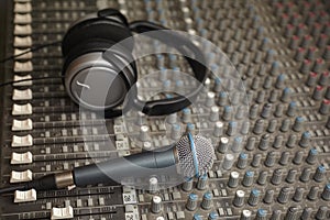 Headphones and microphone on old dirty sound mixer