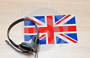 Internet learning of English. Top view of headphones and flag of Great Britain.