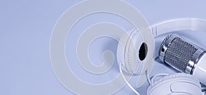 Headphones and microphone for sound recording. Light purple background. Copy space. Banner violet