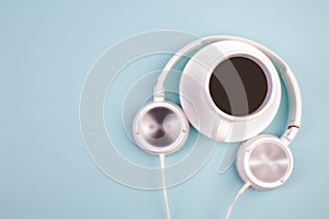 Headphones, mobile phone, idiobook, coffee cup on a blue background. The concept of leisure and learning, hobby. Listen to music,