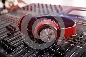 Headphones on professional mixing console in modern radio studio, closeup