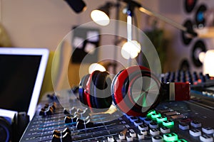 Headphones on professional mixing console in radio studio