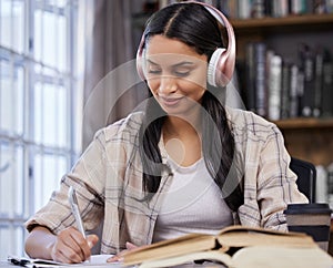 Headphones, study and girl with notebook in library for music, learning or studying for exam. University, student and