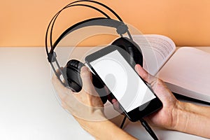 Headphones in woman hands. Listen to Audiobook. Reading book in audio. Online education and e-learning concept