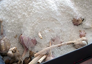 Heads of garlic are stored under a layer of salt