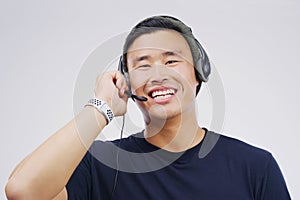 Headset, asian man and smile in call center in portrait on white background with telemarketing or crm. Customer support