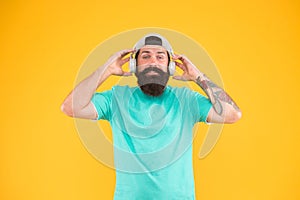Headset with ergonomic design. Hipster wearing adjustable white headset on yellow background. Bearded man listening to