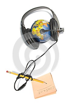 Headset on world globe with pencil and note isolat