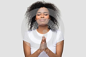 Headshot african female praying posing on grey background studio shot