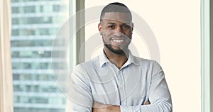 Headshot ambitious African businessman posing in office with arms crossed