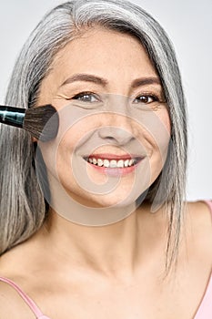 Headshot of Asian mature woman's face with perfect natural makeup.
