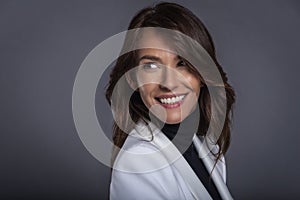 Headshot of an attractive cheerful smiling woman standing agains  background