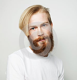 Headshot of attractive serious Caucasian male with thick ginger beard