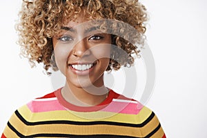 Headshot of attractive tender and friendly-looking outgoing joyful young dark-skinned woman with fair curly haircut in