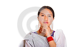 Headshot beautiful young woman wearing traditional andean shawl and red necklace, posing for camera using hands touching