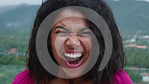 Headshot. Close-up portrait of beautiful young multiethnic woman looking at camera, rejoicing, expressing stupefaction