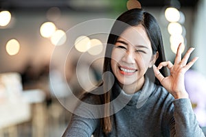 Headshot of cute girl gesture hand okay sign feeling positive.