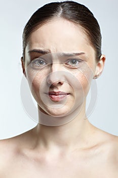 Headshot of emotional female face portrait with displeasure facial expression