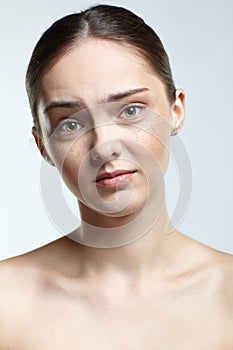 Headshot of emotional female face portrait with regretful, facial expression