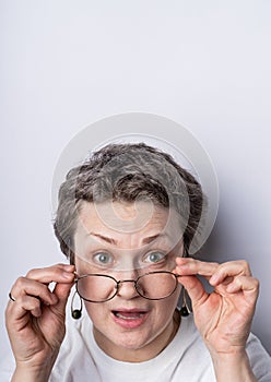 Headshot of a gray haired woman 40-50 with glasses having playful expression on her face