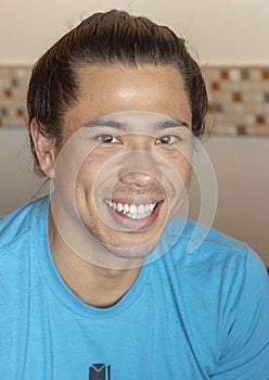 Headshot of handome Amerasian young man, indoors.