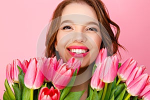 headshot of happy woman with bouquet of spring flowers